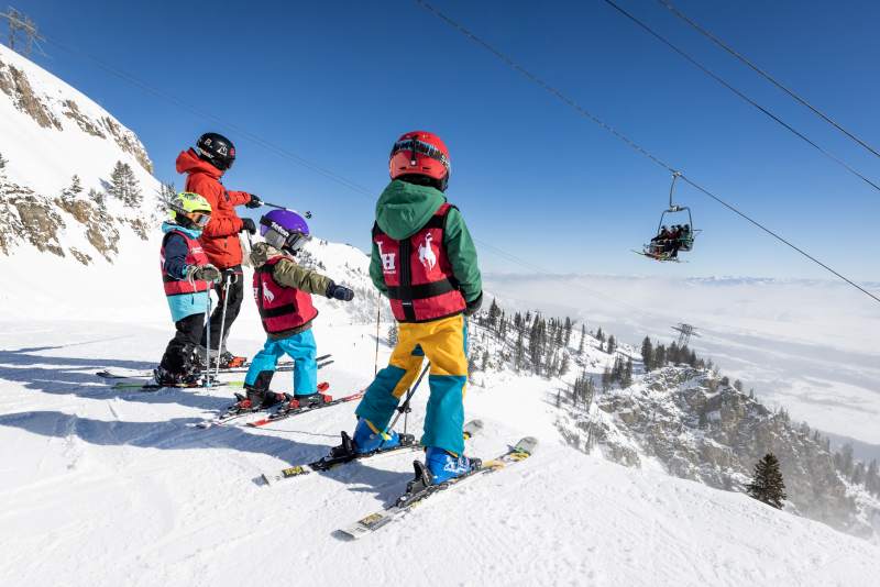 Group of kids in colorful ski gear preparing to ski near a lift at Jackson Hole Mountain Resort