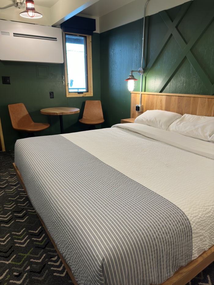 Private king room with natural light, desk, and green feature wall