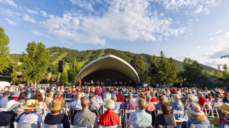 A large crowd enjoys an outdoor music festival