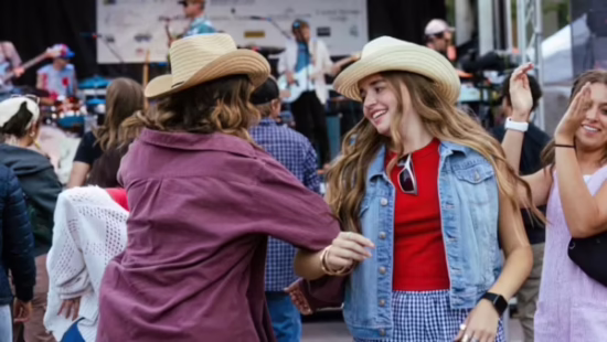 two women dancing wearing cowboy hats