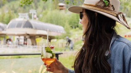 a woman drinking in the mountains